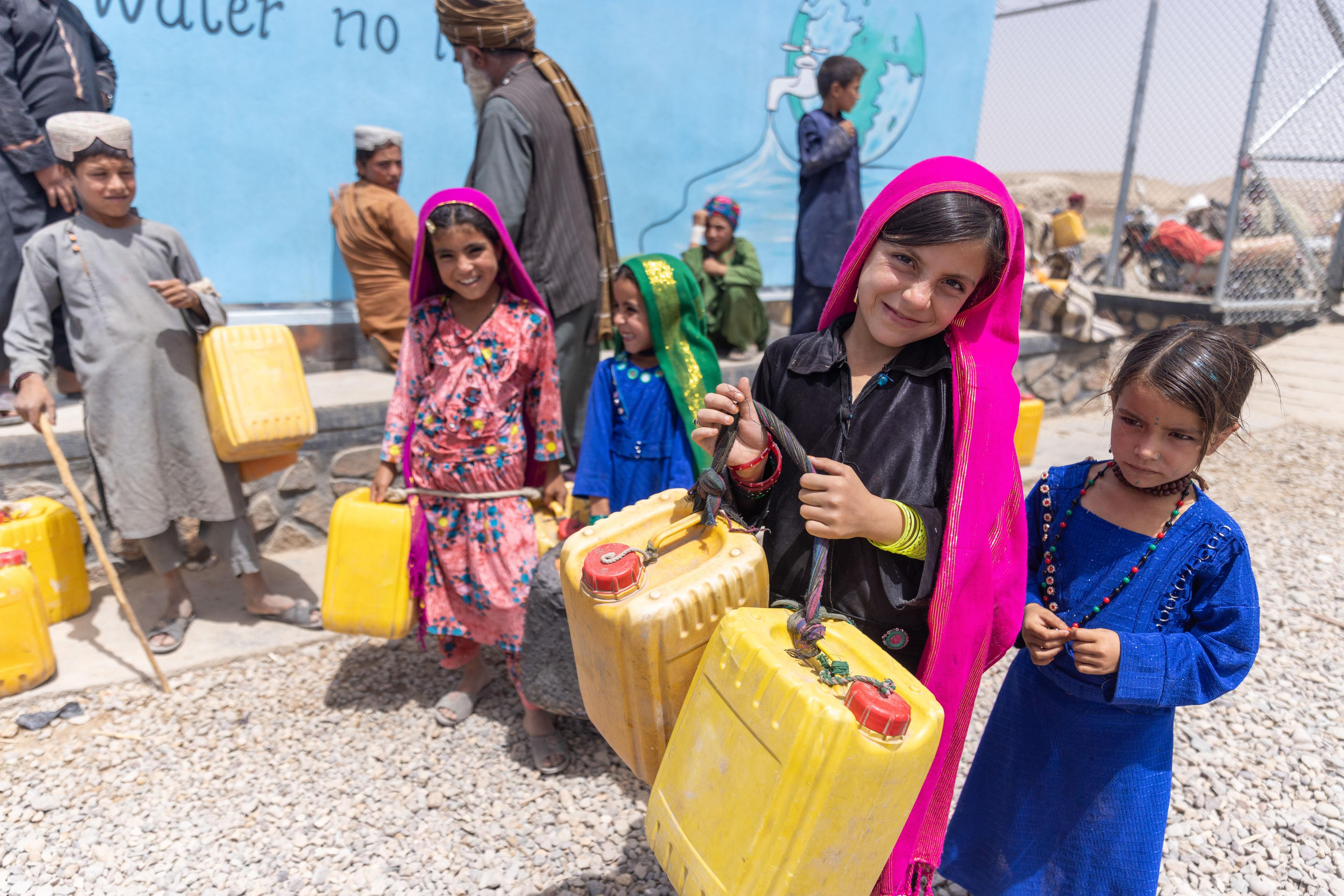 Barn samlar vatten vid vattenstation - Afghanistan 2023 