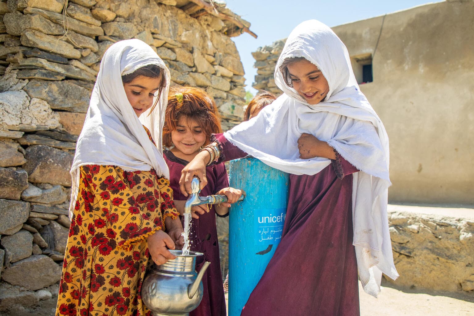 Barn vid vattenpump - unicef logo - Afghanistan 2024