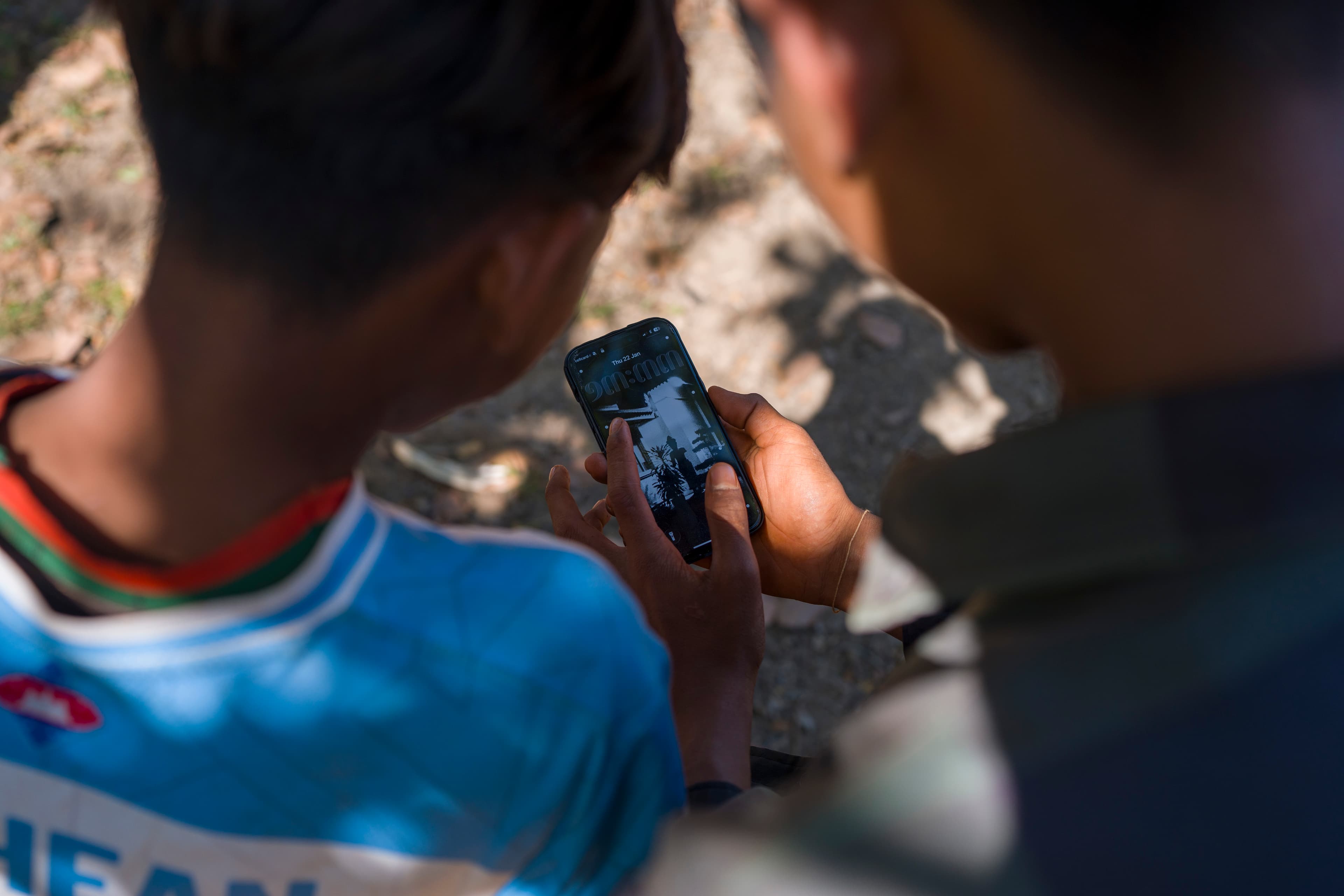 Pojkar som använder telefon - SoMe - Kambodja 2026