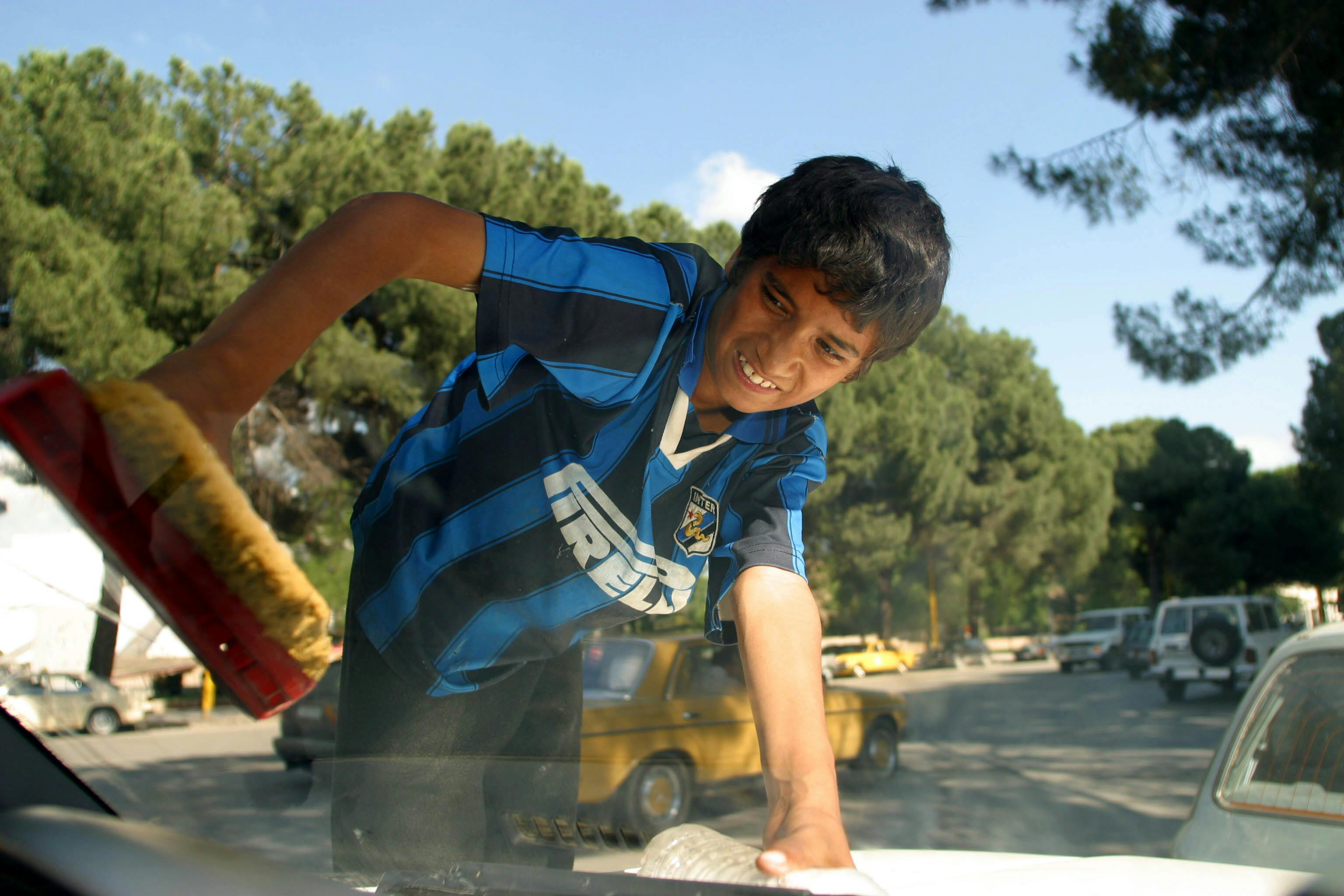 En pojke tvättar bilfönster, Albanien