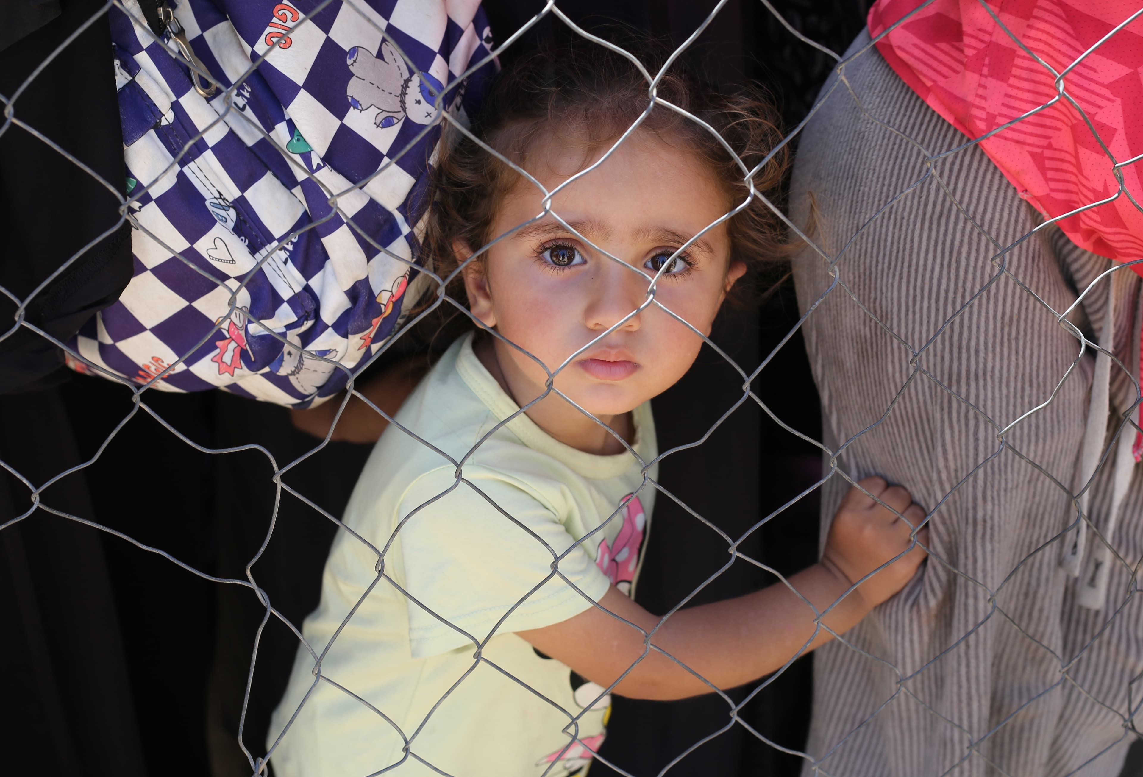 Barn med vuxna - bakom stängsel - Gaza - maj 2025 - cropped mobil
