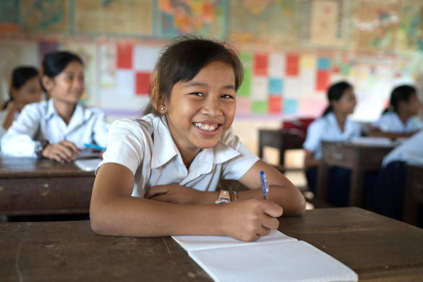 En flicka ler i ett klassrum i Kambodja
