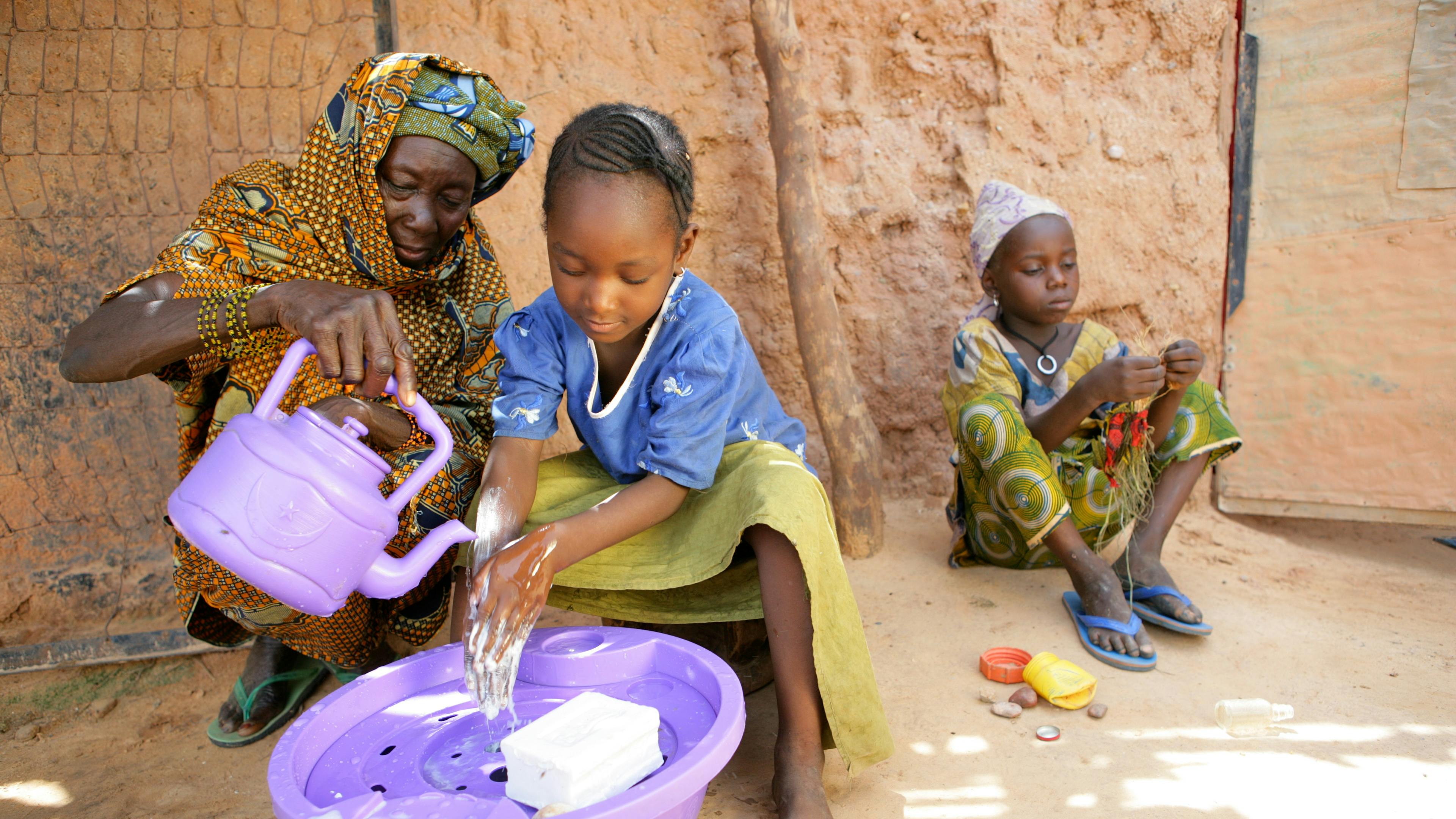 En flicka i Niger tvättar händerna